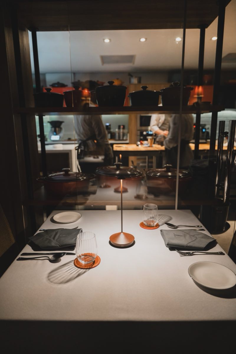 Mesa posta de frente para a cozinha envidraçada do Tarso